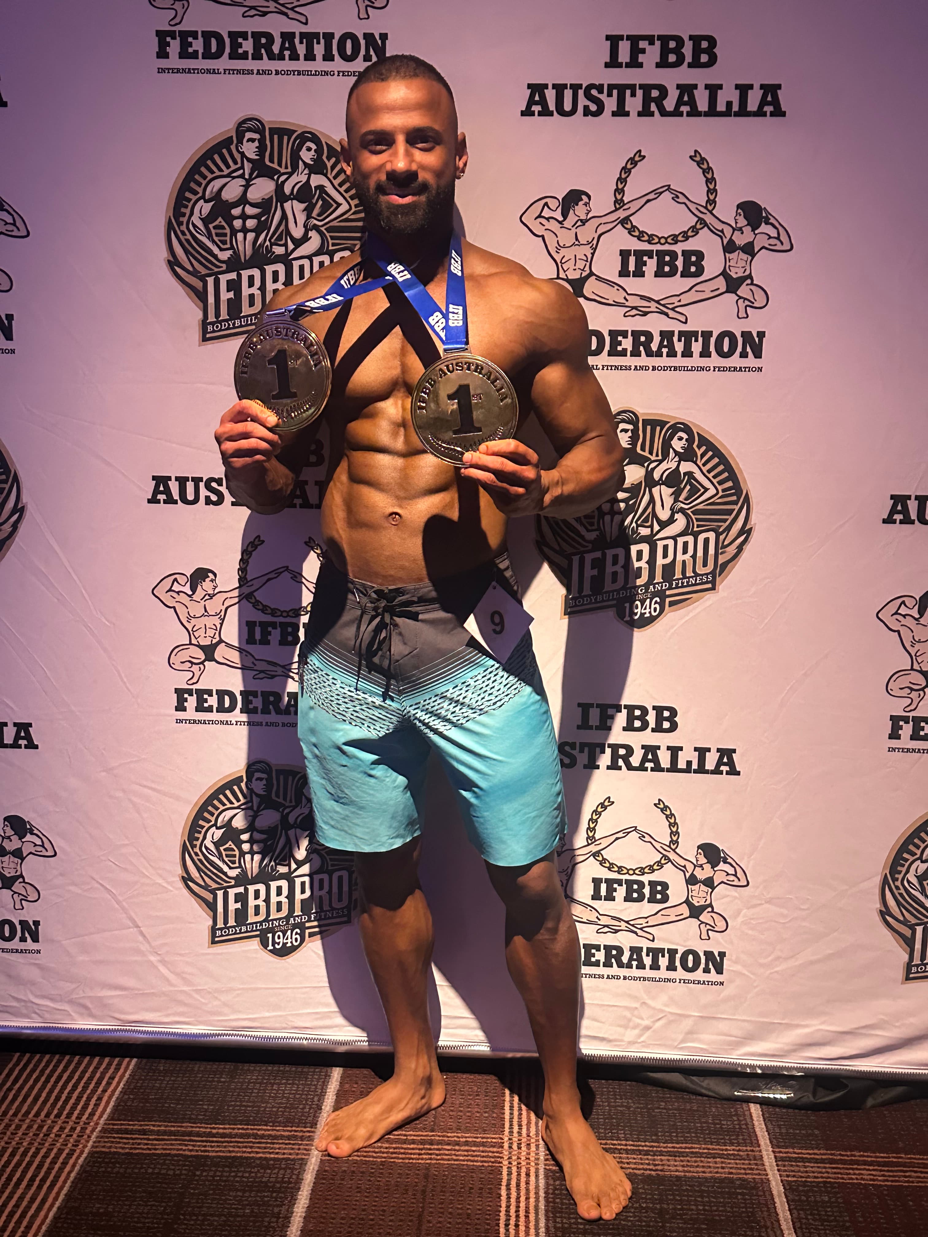 Puneet at IFBB Australia holding two gold medals